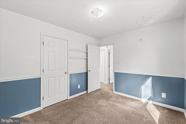 unfurnished bedroom featuring carpet and baseboards