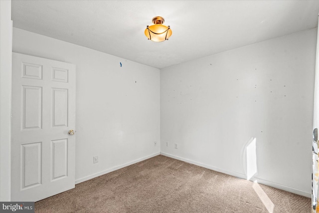 empty room with carpet and baseboards