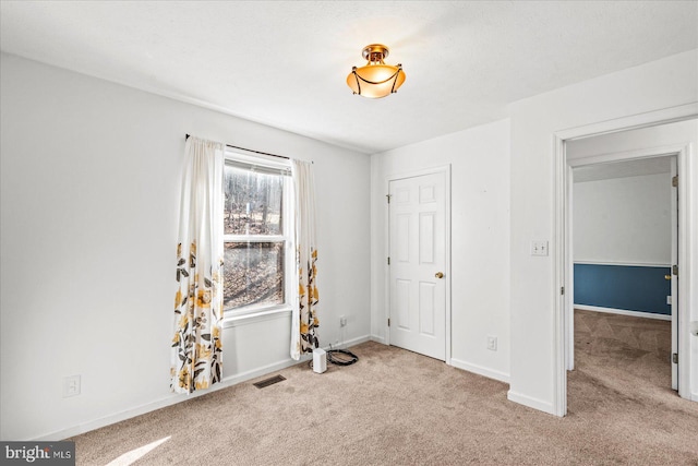 unfurnished bedroom featuring visible vents, baseboards, and carpet flooring