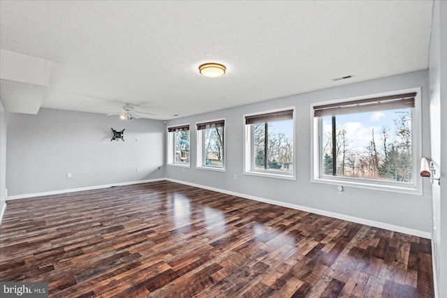 spare room with dark wood finished floors and baseboards