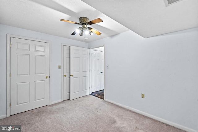 unfurnished bedroom featuring carpet floors, ceiling fan, baseboards, and a textured ceiling