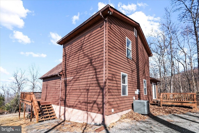 view of property exterior featuring central air condition unit and a wooden deck