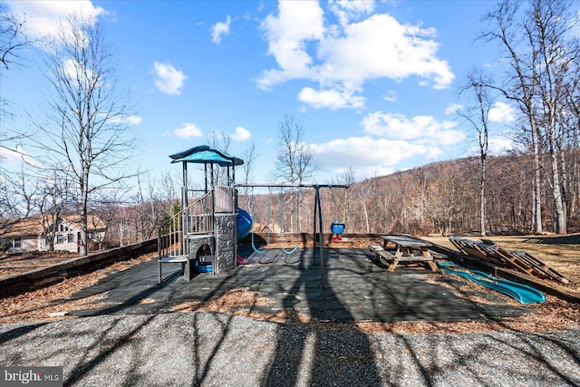 community playground featuring a view of trees