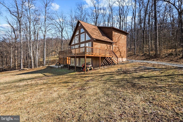 view of property exterior featuring stairs, a yard, a deck, and a view of trees