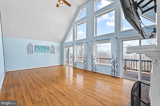 unfurnished living room featuring ceiling fan, baseboards, and wood finished floors