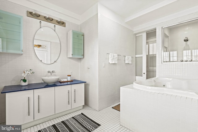 bathroom featuring tile patterned flooring, vanity, tile walls, a jetted tub, and a tile shower