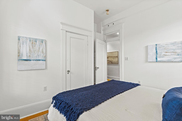 bedroom featuring wood finished floors and baseboards