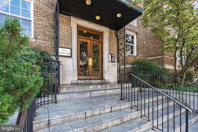 doorway to property featuring brick siding and french doors