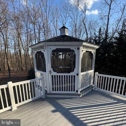 wooden deck featuring a sunroom and a gazebo