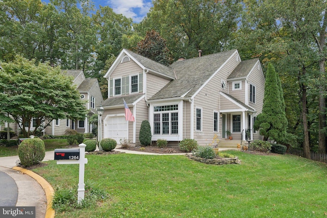 traditional-style home with an attached garage, driveway, and a front lawn