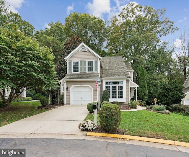 view of front facade with an attached garage, a front lawn, and concrete driveway