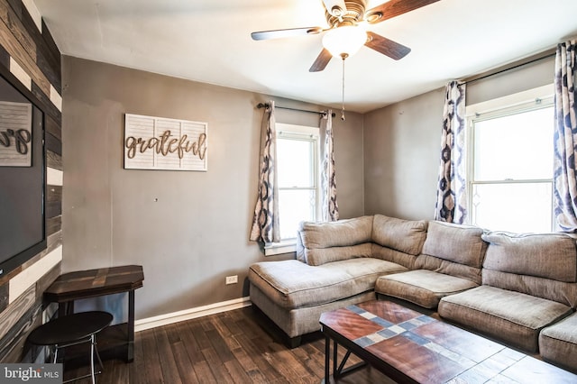 living area with dark wood-style flooring, ceiling fan, and baseboards