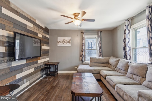 living room with plenty of natural light, baseboards, ceiling fan, and dark wood-style flooring