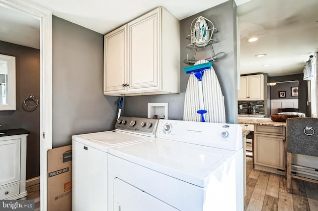 clothes washing area with light wood-style floors, separate washer and dryer, and recessed lighting