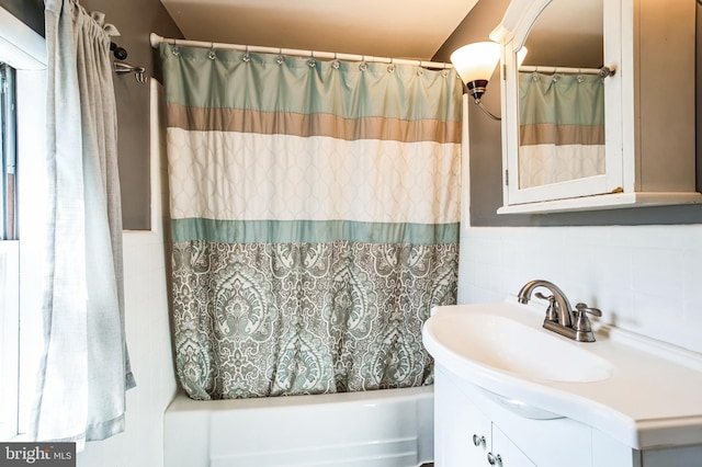 bathroom with shower / tub combo with curtain, tile walls, and vanity