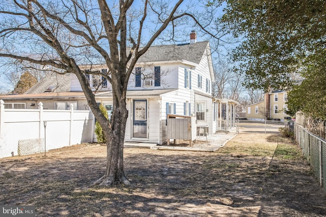 exterior space featuring a shingled roof, a fenced backyard, and a chimney