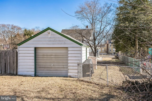 detached garage featuring fence and driveway