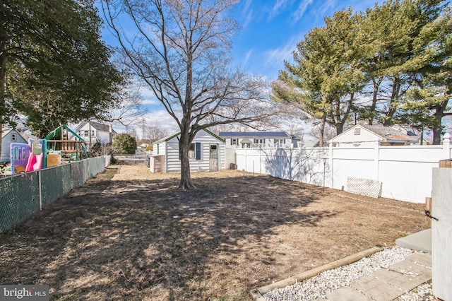 view of yard with a playground, a fenced backyard, and an outdoor structure