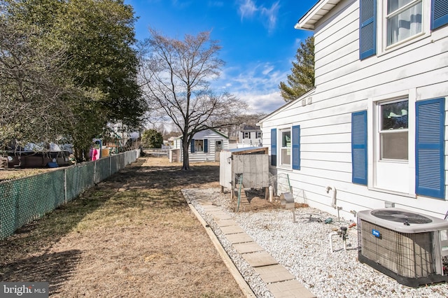 view of yard featuring fence and central AC unit