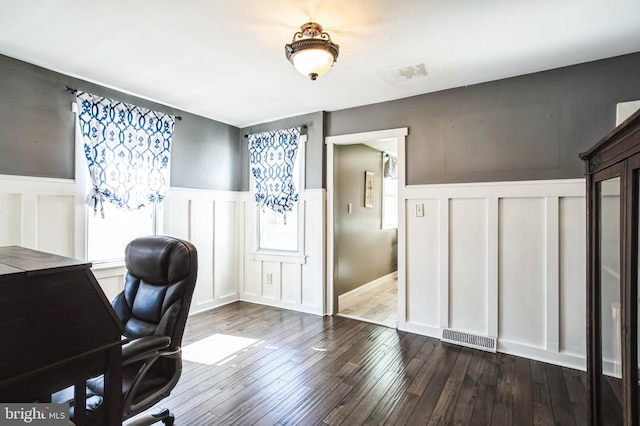 office area with a wainscoted wall, visible vents, a decorative wall, and dark wood-type flooring