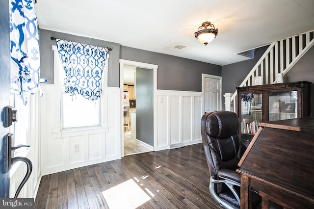 office with a wainscoted wall, wood finished floors, visible vents, and a decorative wall