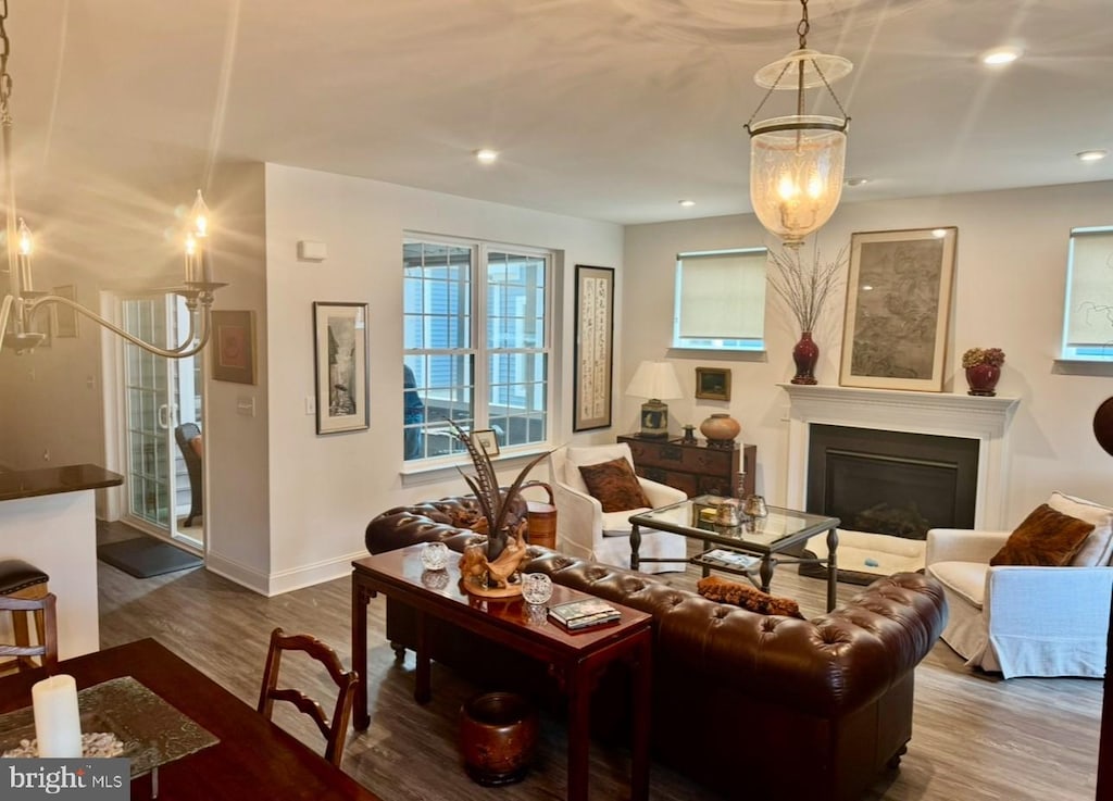 living room with recessed lighting, stairway, a glass covered fireplace, wood finished floors, and baseboards