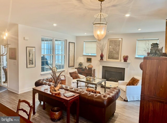 living room featuring a glass covered fireplace, wood finished floors, and recessed lighting