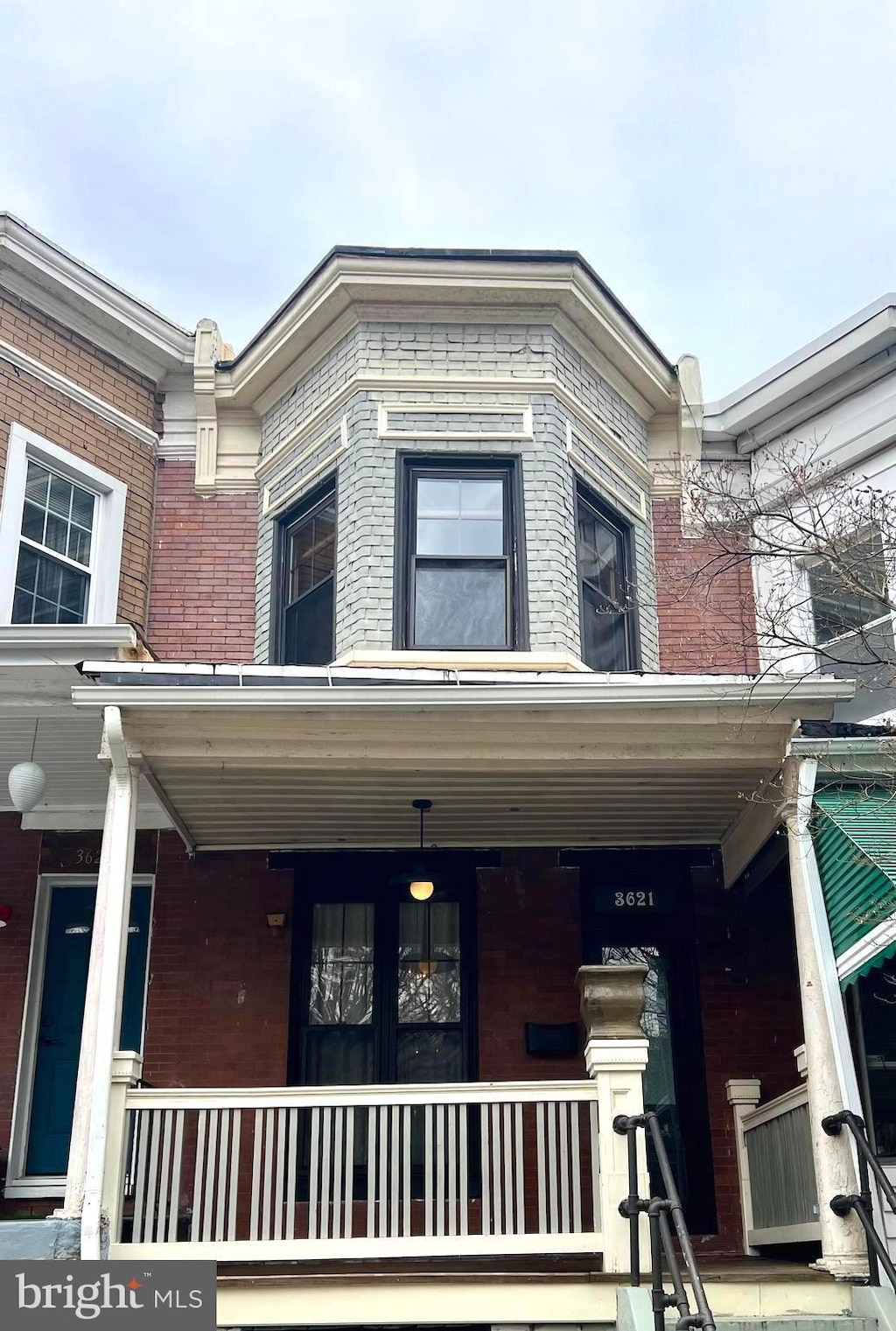 exterior space with covered porch and brick siding