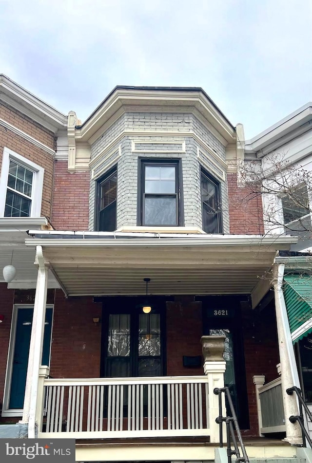 exterior space with covered porch and brick siding