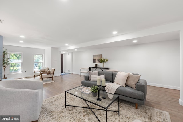 living area featuring baseboards, recessed lighting, and wood finished floors