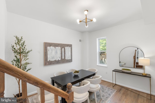 dining room with baseboards, wood finished floors, and a notable chandelier