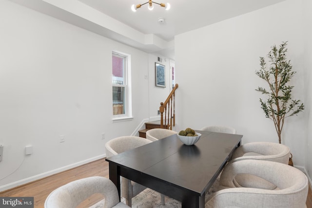 dining space with baseboards, visible vents, stairway, and light wood-type flooring