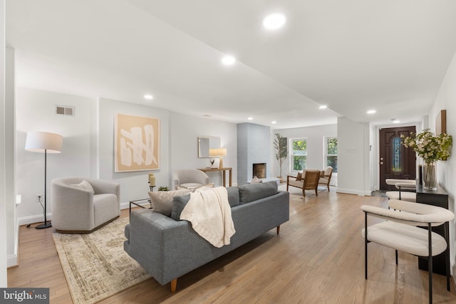 living room featuring recessed lighting, a baseboard radiator, light wood finished floors, and visible vents