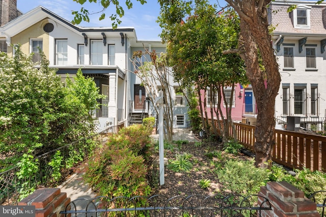 exterior space with mansard roof and fence