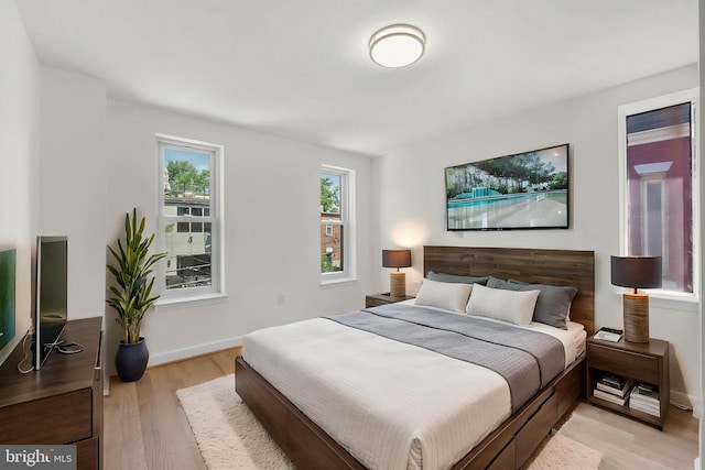 bedroom with baseboards and light wood-style flooring