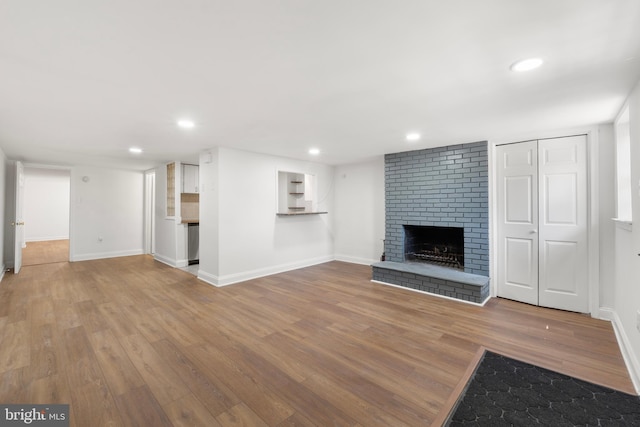 unfurnished living room featuring baseboards, a fireplace, recessed lighting, and wood finished floors