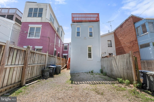 back of house featuring a fenced backyard and stucco siding