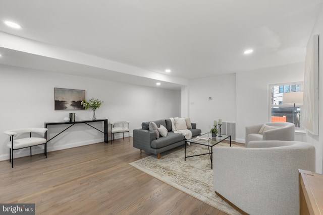 living room with recessed lighting, baseboards, and light wood-type flooring