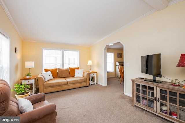 living area featuring carpet, arched walkways, baseboards, and ornamental molding