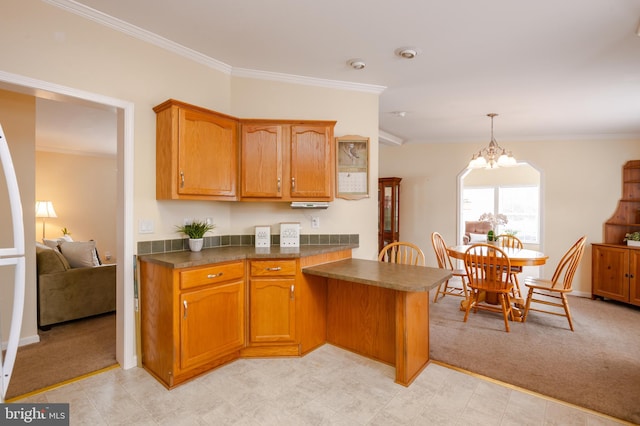 kitchen with dark countertops, brown cabinetry, and light colored carpet