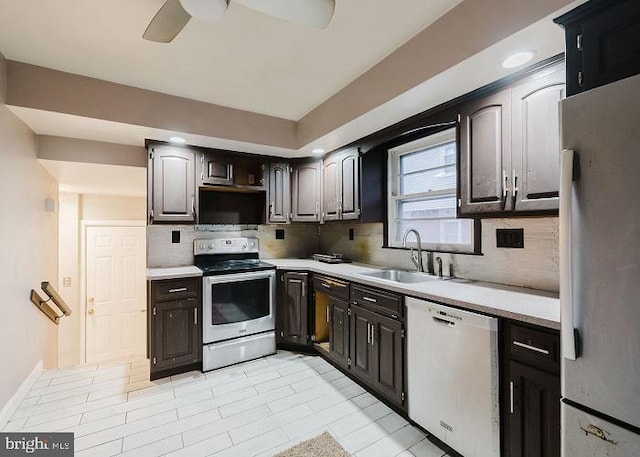 kitchen featuring light countertops, white appliances, backsplash, and a sink