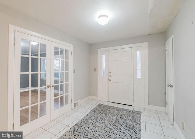 foyer featuring tile patterned flooring, french doors, visible vents, and baseboards