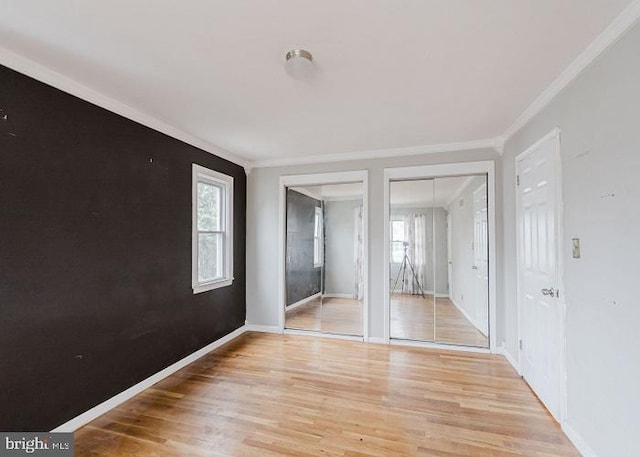 empty room with light wood-type flooring, baseboards, and ornamental molding