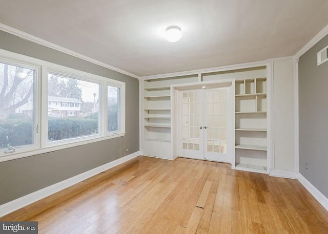 unfurnished bedroom featuring visible vents, baseboards, wood finished floors, crown molding, and french doors