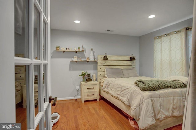 bedroom with recessed lighting, visible vents, baseboards, and wood finished floors