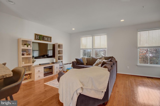 living area with plenty of natural light, wood-type flooring, and recessed lighting