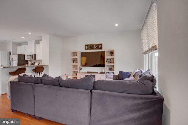 living area featuring light wood finished floors and recessed lighting