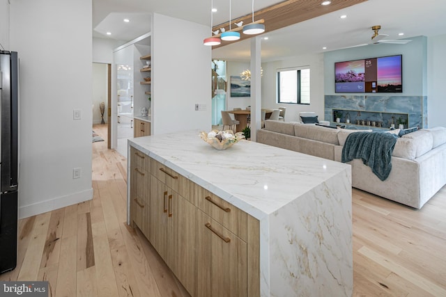 kitchen featuring light wood-type flooring, light brown cabinets, modern cabinets, and a center island