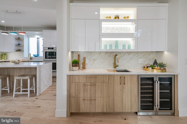 kitchen featuring wine cooler, a sink, open shelves, and modern cabinets