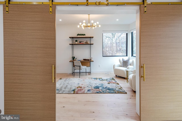 unfurnished room with recessed lighting, an inviting chandelier, a barn door, wood finished floors, and baseboards